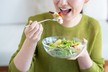 サラダを食べる若い女性