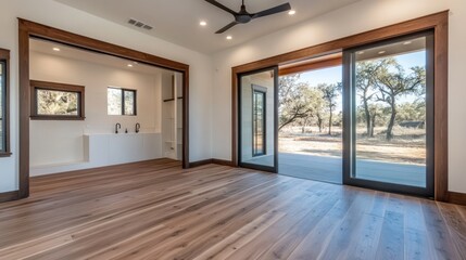 Obraz premium Modern interior of a home with hardwood floors, sliding glass doors, and a view of the outdoors.