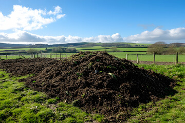 Heap of natural compost material in a rural farmyard setting