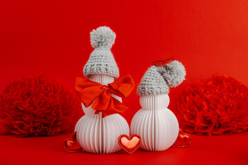 Snowmen couple in love with handmade felt heart. Festive greeting card concept, Valentine's Day