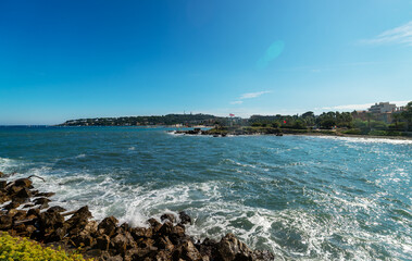 Antibes seaside promenade with palm trees.