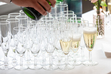 Flutes de champagnes entrain d'être remplies sur une table de réception