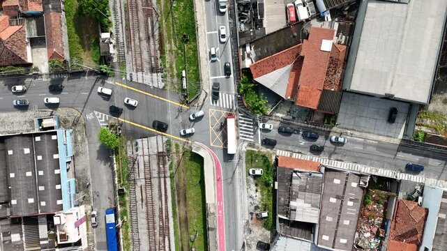 V&iacute;deo 4K com vis&atilde;o a&eacute;rea do tr&acirc;nsito em um cruzamento movimentado sobre a linha de trem na cidade de Mogi das Cruzes, SP, Brasil, destacando a mobilidade e infraestrutura urbana