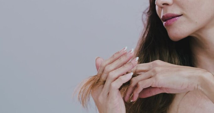 Hands, hair and split ends in studio with mature woman, check and mock up space by gray background. Person, model and inspection for growth, damage and decision to change hairstyle with bad results