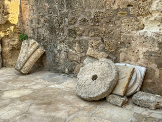 Fragments of ancient buildings located near the former St. Nichola Cathedral in Famagusta, Northern Cyprus. Among others, a millstone, e.g. from an olive oil press