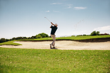 Male golfer in a stance showcasing a powerful swing - obrazy, fototapety, plakaty