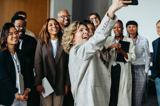 Team gathering for a joyful photo as coworkers capture a memorable moment together during a break at a professional event - Powered by Adobe