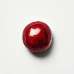 Obraz premium Glossy pomegranate seed isolated on a clean white surface showcasing its vibrant red hue and smooth texture