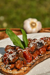 Bruschetta with fresh tomatoes, eggplant and basil on a picnic basket. Traditional Italian appetizer                                                                               