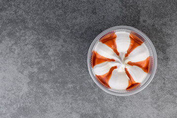 Ice cream jar with caramel on gray background.