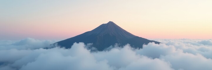 Fototapeta premium Misty mountaintop emerges from swirling cloudscape, lone silhouette against pale sky , isolated, aerial, elevated