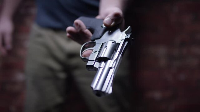 Second Amendment - Man hands over his firearm weapon revolver