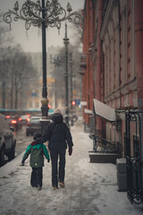 mother and son walking through a snowy city