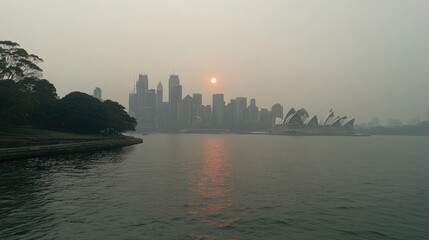 Fototapeta premium A city skyline at sunrise, the sun barely visible through the thick haze.