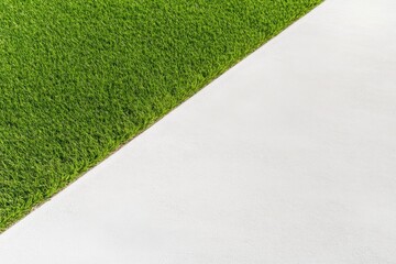 Perfectly edged green lawn contrasts with smooth white concrete, creating a striking minimalist composition emphasizing clean lines and textures