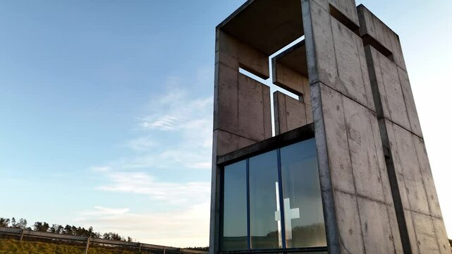 A mesmerizing aerial video of a small chapel beautifully illuminated by the golden sunset. The warm sunlight enhances the architectural details, creating a breathtaking contrast between the sacred str