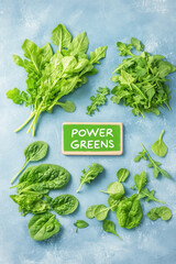 Fresh power greens arranged on blue background, showcasing vibrant leaves