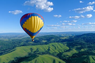 Fototapeta premium Hot Air Balloon Over Rolling Hills - A vibrant hot air balloon floats gracefully over a picturesque landscape of rolling green hills under a bright blue sky.