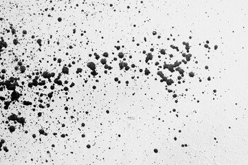 gray background, photograph of black paint splashes on white wall