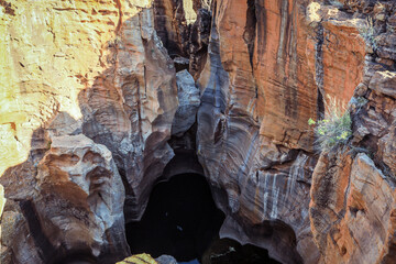 Blyde River Canyon reveals stunning rock formations and dark waters at midday in South Africa