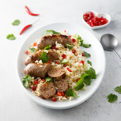 Homemade sausages with rice and pomegranate seeds