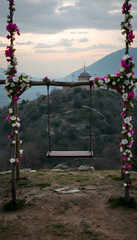 Naklejka premium Kapadokya swings empty on viewpoint to Ortahisar castle with beautiful spring flower decorations, dramatic atmosphere. with white shades