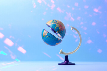 Sliced globe in half with mirrored disco ball inside on pastel blue background with glare. Creative concept of global celebration. Earth Day.