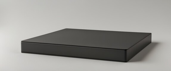 Minimalistic black rectangular object with sleek design, suitable for storage or as a modern display item on a neutral background.