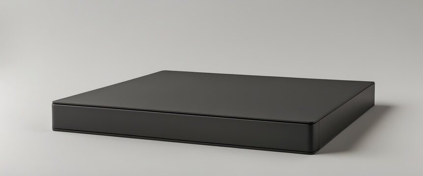 Minimalistic black rectangular object with sleek design, suitable for storage or as a modern display item on a neutral background.