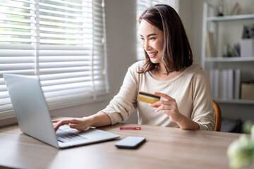 A woman is using a laptop to make a purchase with a credit card