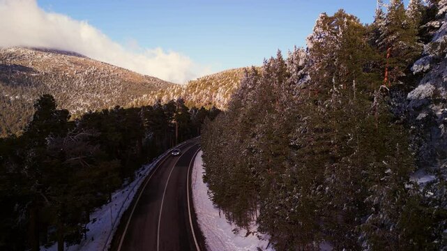 Flying over a lonely road by the mountains in the afternoon