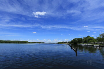 Tranquil lake with tree-covered island under dramatic blue sky