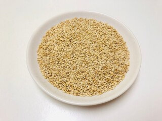 白いお皿に入れた白ごま　健康食品