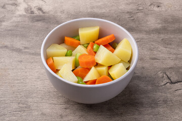 Cooked vegetables in a bowl over wooden table