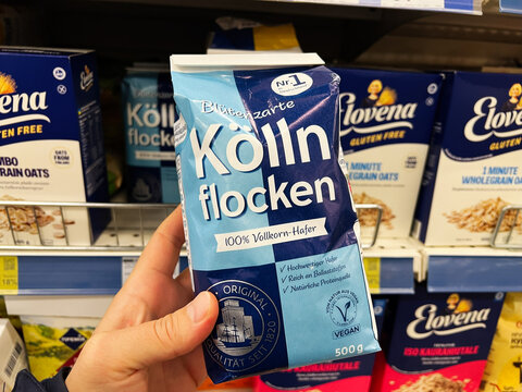 Kyiv, Ukraine - February 04, 2025: Hand Holding a Bag of Kolln Flocken on a Grocery Store Shelf