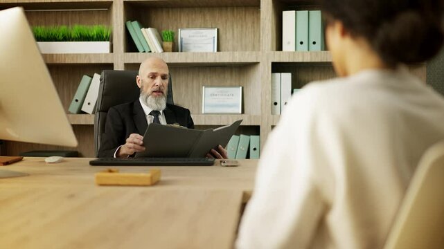 Displeased boss reads a report and berates a woman employee for a failed project