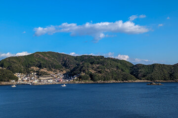 Fototapeta premium 青空と山並みに囲まれた静かな港町