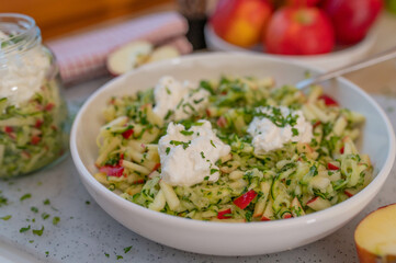 Healthy raw fruit vegetable salad with apples and zucchini topped with protein rich cottage cheese