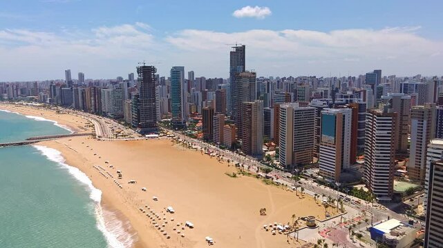 Aerial panorama of Iracema Beach, Fortaleza, Ceara, Brazil. A blend of golden sand, turquoise waters, and a contemporary skyline with skyscrapers. Dynamic urban scene, perfect for tourism