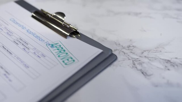 Citizenship application form gets approved, hand stamping the seal on the paper