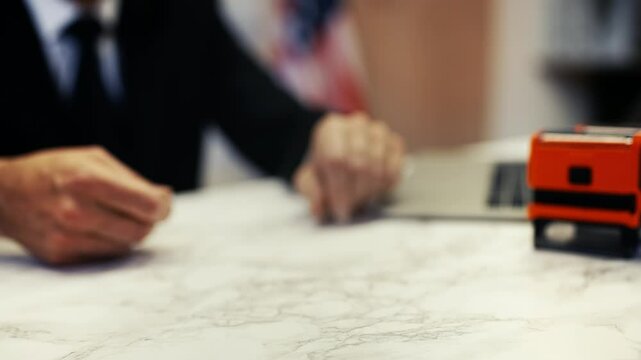 Close-up of a woman receiving a United States passport inside an embassy office
