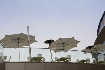 cafe on the terrace tables under a sun umbrella shot from below against the sky
