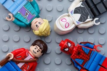Naklejka premium Tambov, Russian Federation - February 03, 2025 Four Lego Marvel character minifigures - Peter Parker, Spider-Man, Gwen Stacy and Ghost-Spider, on a gray baseplate background.