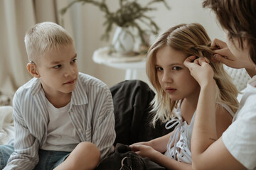 A loving mother with her son and daughter enjoys the magical atmosphere of Christmas and New Year. The family shares joyful moments, playing together, laughing, and creating warm holiday memories