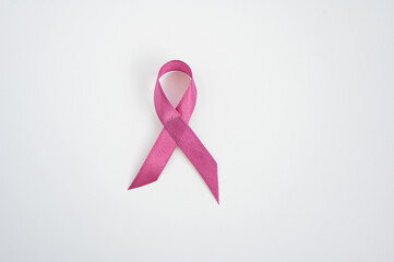 Pink ribbon on white background symbolizing breast cancer awareness and support. Childhood Cancer...