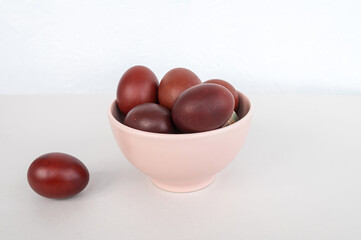 Bowl of brown eggs on white surface