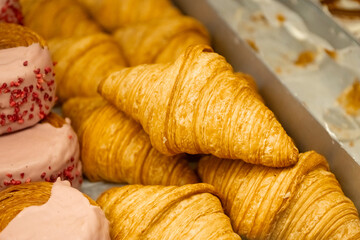 National Croissant Day Golden flaky croissants stacked in a display tray.