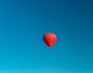 a minimalist shot of a lone red hot air balloon floating in a clear blue sky
