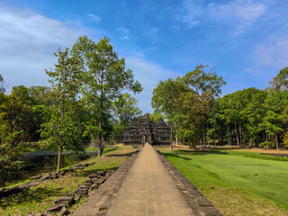 The beautiful walkway of  Baphuon temple with blue sky and green grass in Angkor wat and Angkor Thom at Siem Reap, Cambodia.