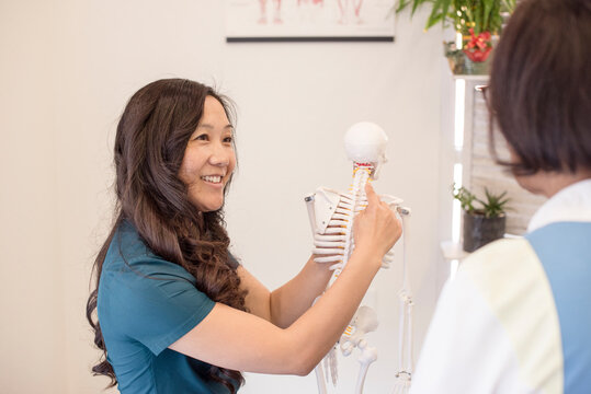 Doctor showing patient the skeleton cervical neck